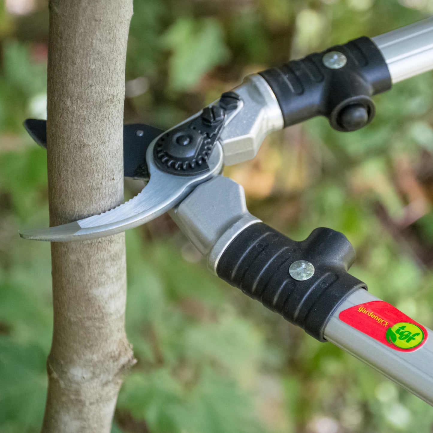 The Gardener's Friend Ratchet Pruning Shears cutting a branch with gardening shears.