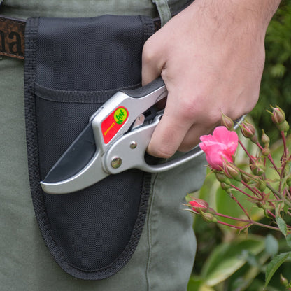 Mans hand holding ratchet pruners by his side in front of a holster attached to his belt