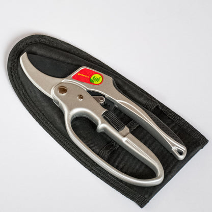 A pair of ratchet pruners lay on top of a holster on a pure white background